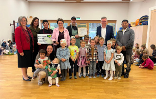 Kindergarten-Leiterin Marianne Kapelarie, Sonja Fidersek (Gesundheitsförderung, Land Kärnten), Isabella Hartl (Küchenteam), Landesrätin Beate Prettner, Küchenchef Jürgen Tomantschger, Bgm. Andreas Scherwitzl, Geist. Rat Pater Vijaya Madanu (von links) und vorne Claudia Pirker (KITA-Gruppenführung; vorne) mit Kindern